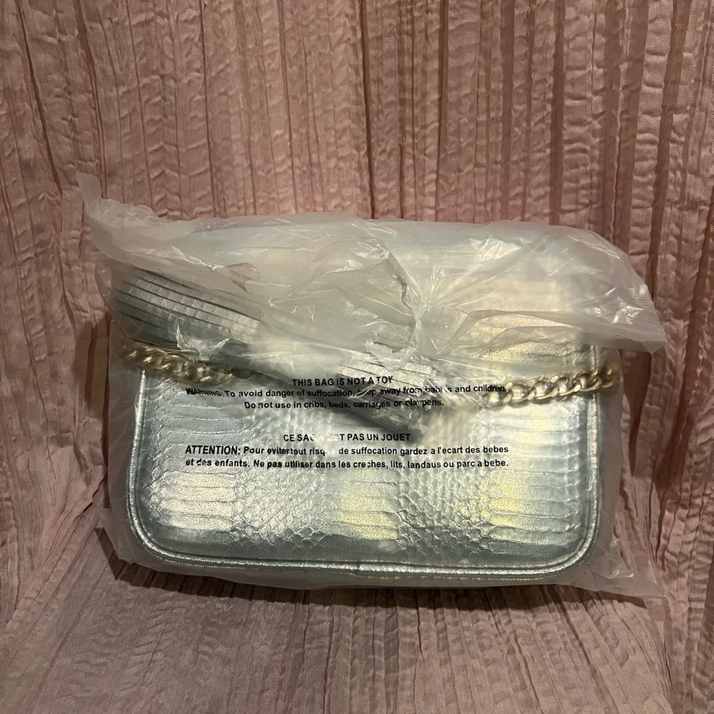 Victoria’s Secret silver snake skin purse with gold chain strap.